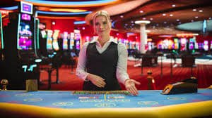 Live dealer croupier at a blackjack table with multi-camera broadcast